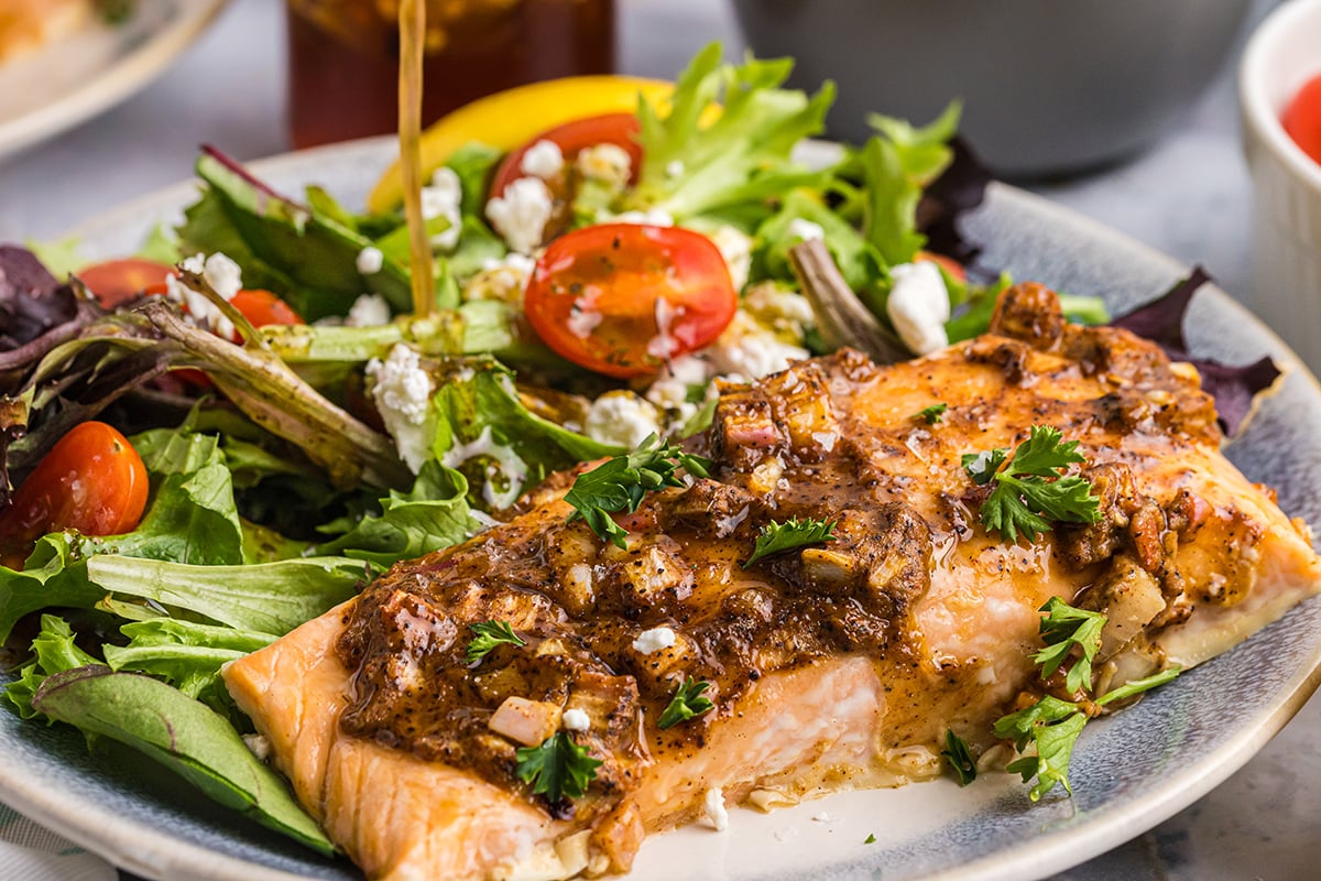 angled shot of hot honey salmon on salad