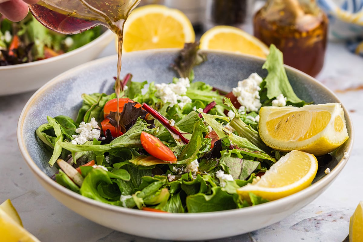 angled shot of dressing poured onto salad