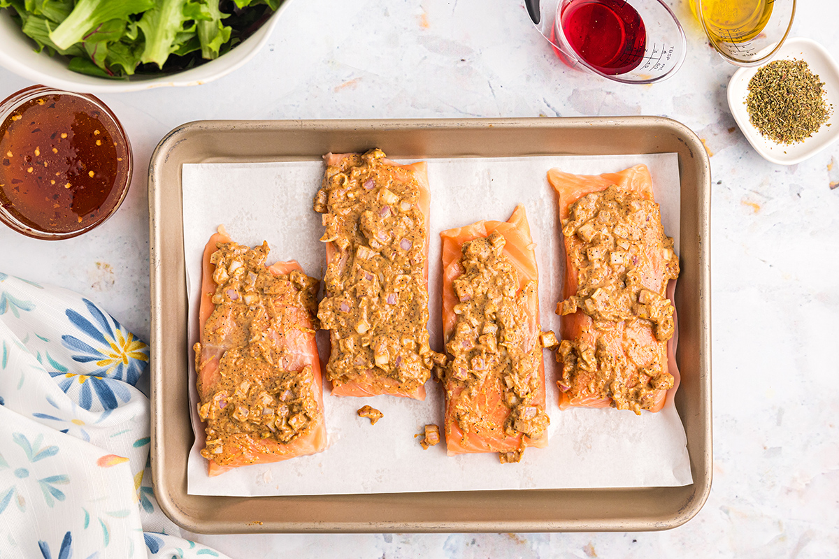 salmon on sheet pan topped with seasoning