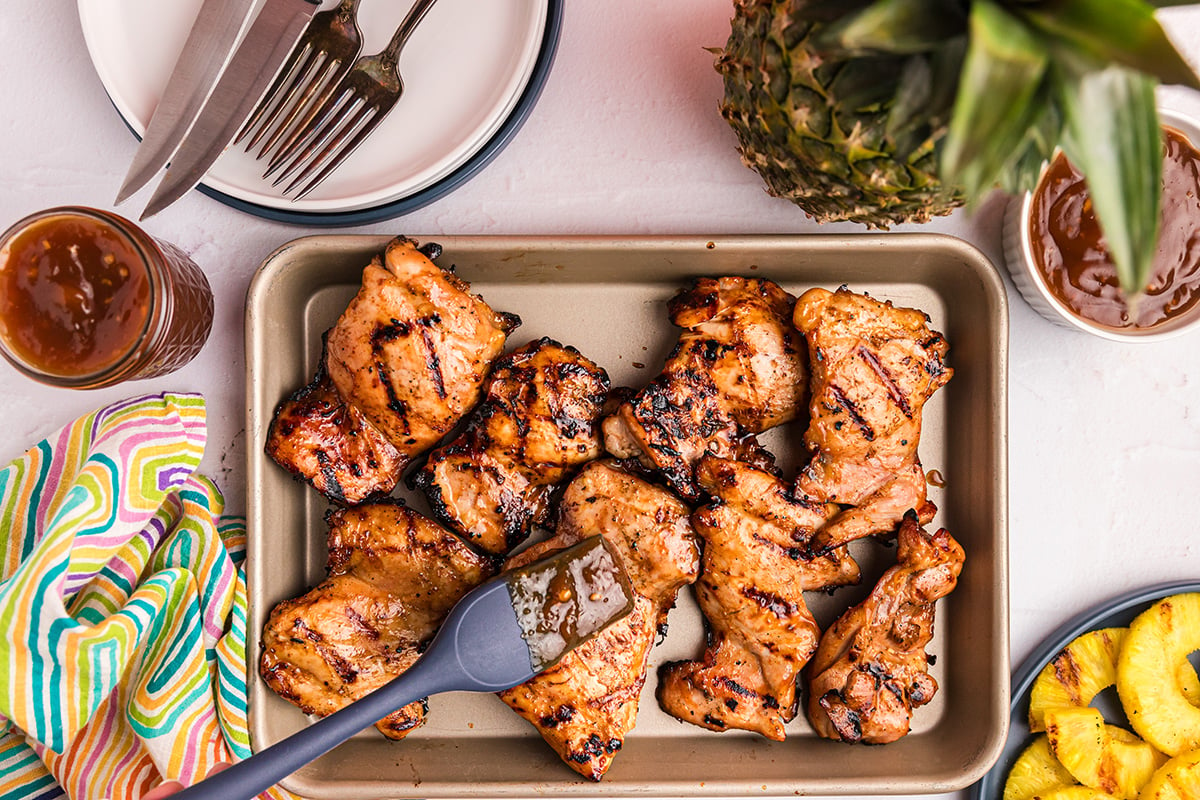 overhead shot of basting huli huli chicken on sheet pan