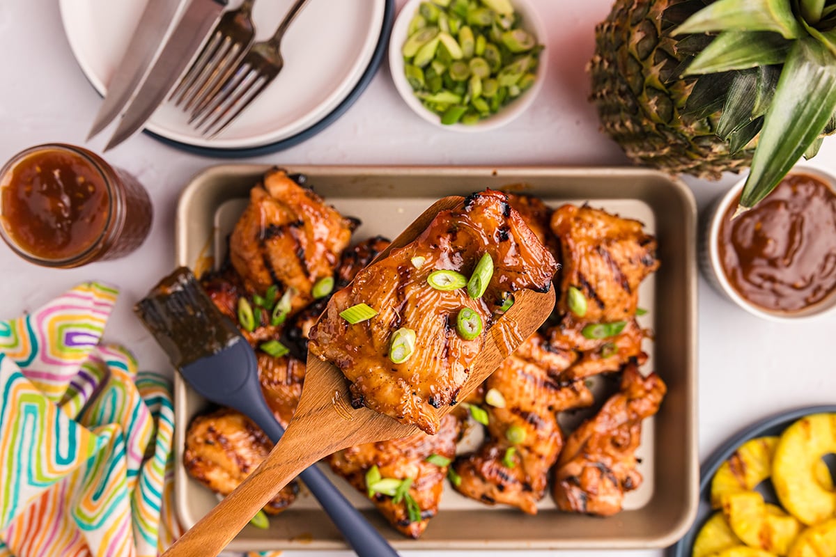 overhead shot of huli huli chicken on wooden spatula