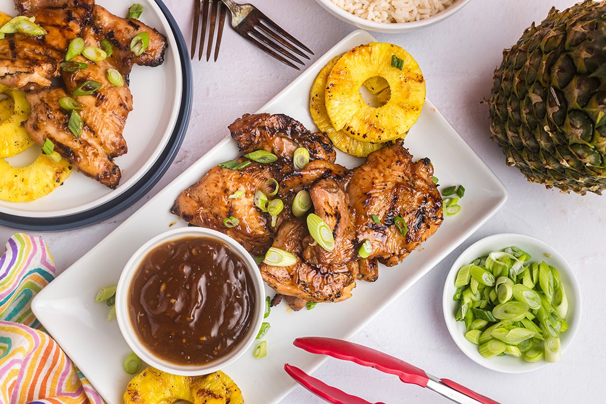 overhead shot of huli huli chicken on platter with sauce and pineapple