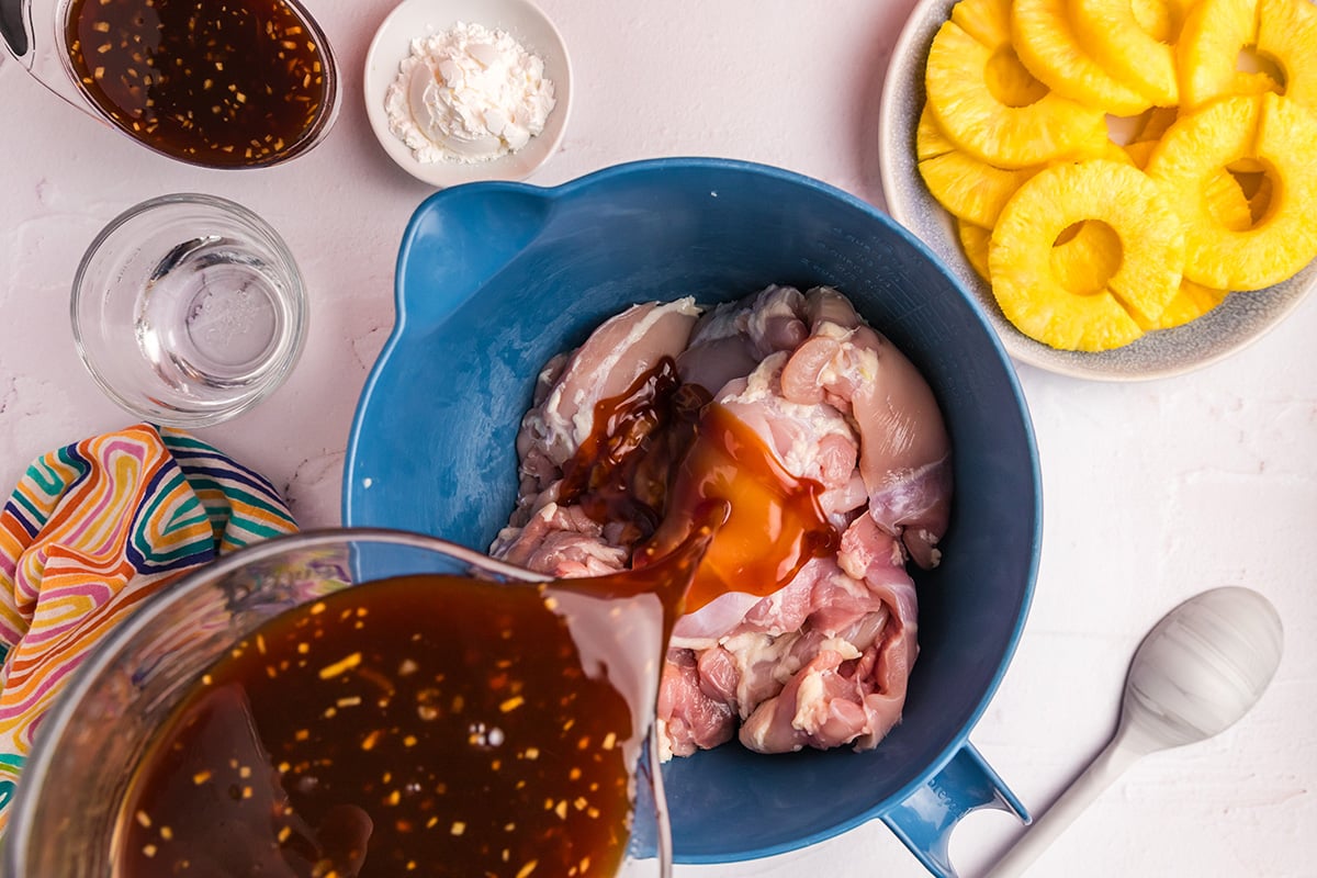 overhead shot of huli huli sauce poured over raw chicken