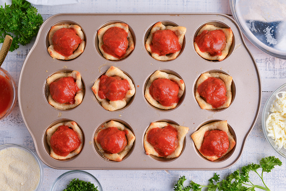 meatballs added to cooked pizza dough