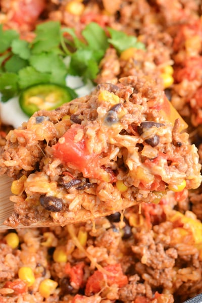 overhead shot of wooden spoon in pan of mexican ground beef casserole