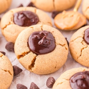 angled shot of peanut butter thumbprint cookies on parchment paper