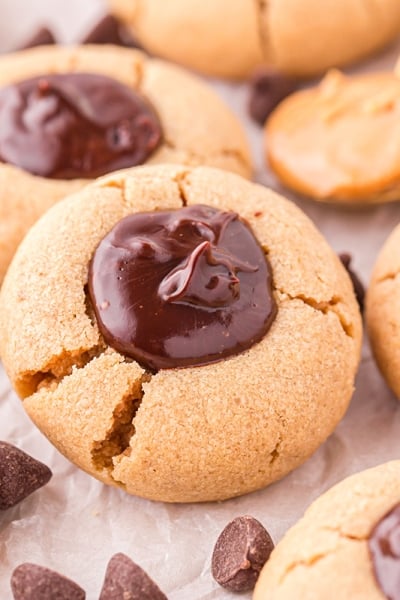 angled shot of peanut butter thumbprint cookies on parchment paper