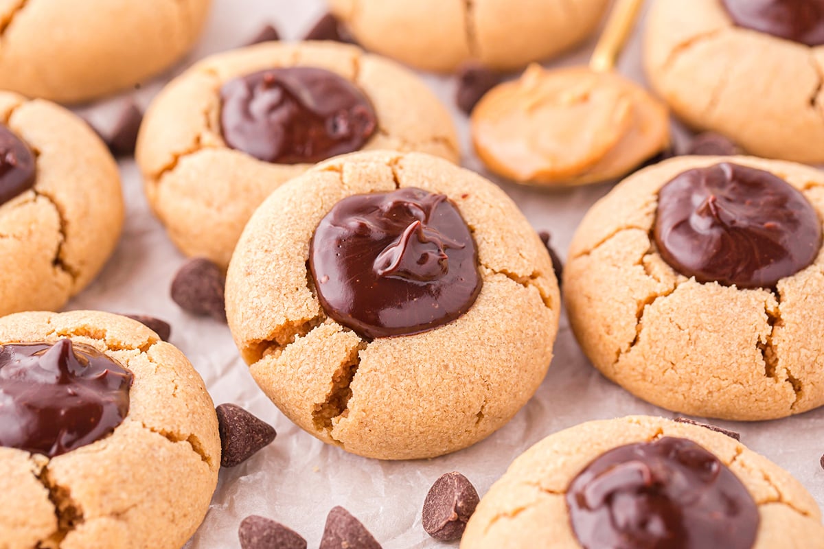 angled shot of peanut butter thumbprint cookies on parchment paper