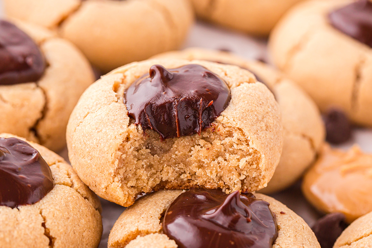 close up of bite taken out of peanut butter thumbprint cookie