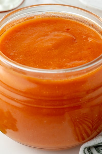 angled shot of jar of homemade enchilada sauce
