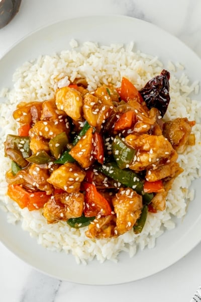 overhead shot of szechuan chicken over rice on a plate