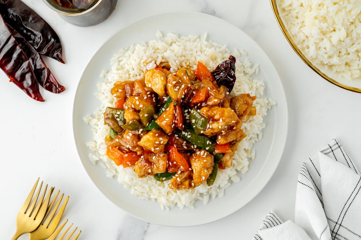 overhead shot of szechuan chicken over rice on a plate