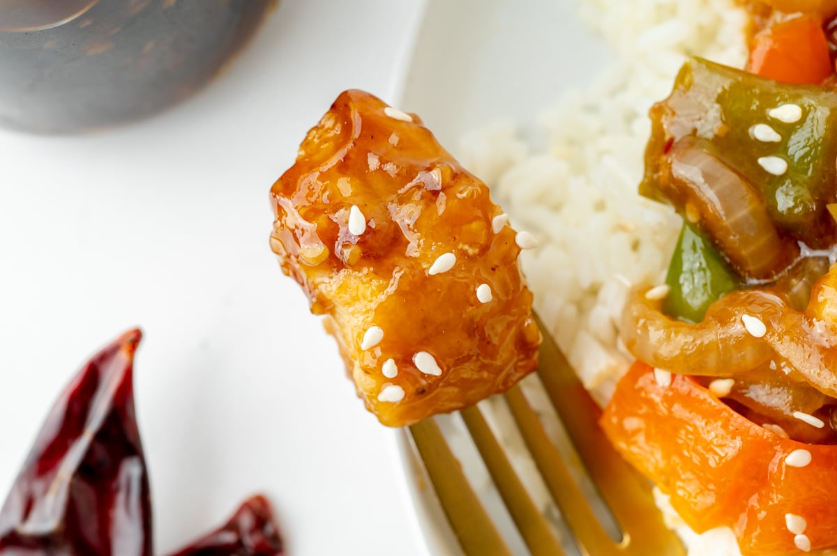 close up of szechuan chicken on a fork