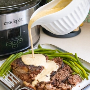 angled shot of sauce pouring over pot roast