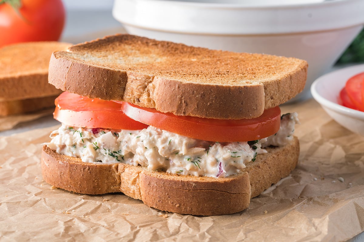 angled shot of tuna salad sandwich on parchment paper
