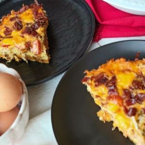 angled shot of two plates with chicken breakfast casserole slices