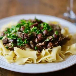 angled shot of plate of Mediterranean beef roast over noodles