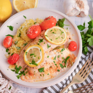 angled shot of lemon garlic butter baked tilapia on plate