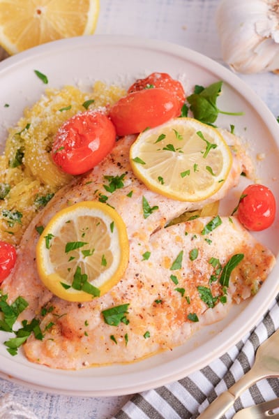 angled shot of lemon garlic butter baked tilapia on plate