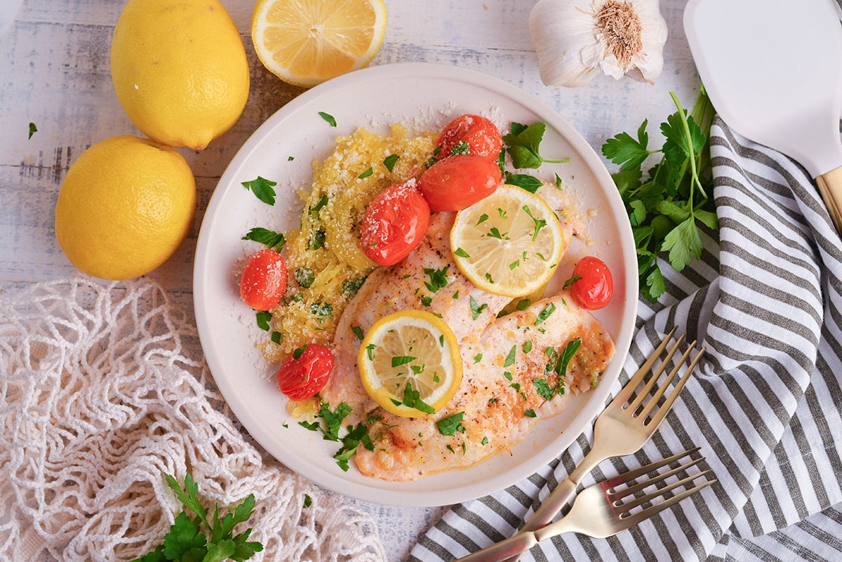 close up overhead shot of lemon garlic butter baked tilapia on plate