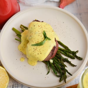 angled shot of bearnaise sauce over beef and asparagus