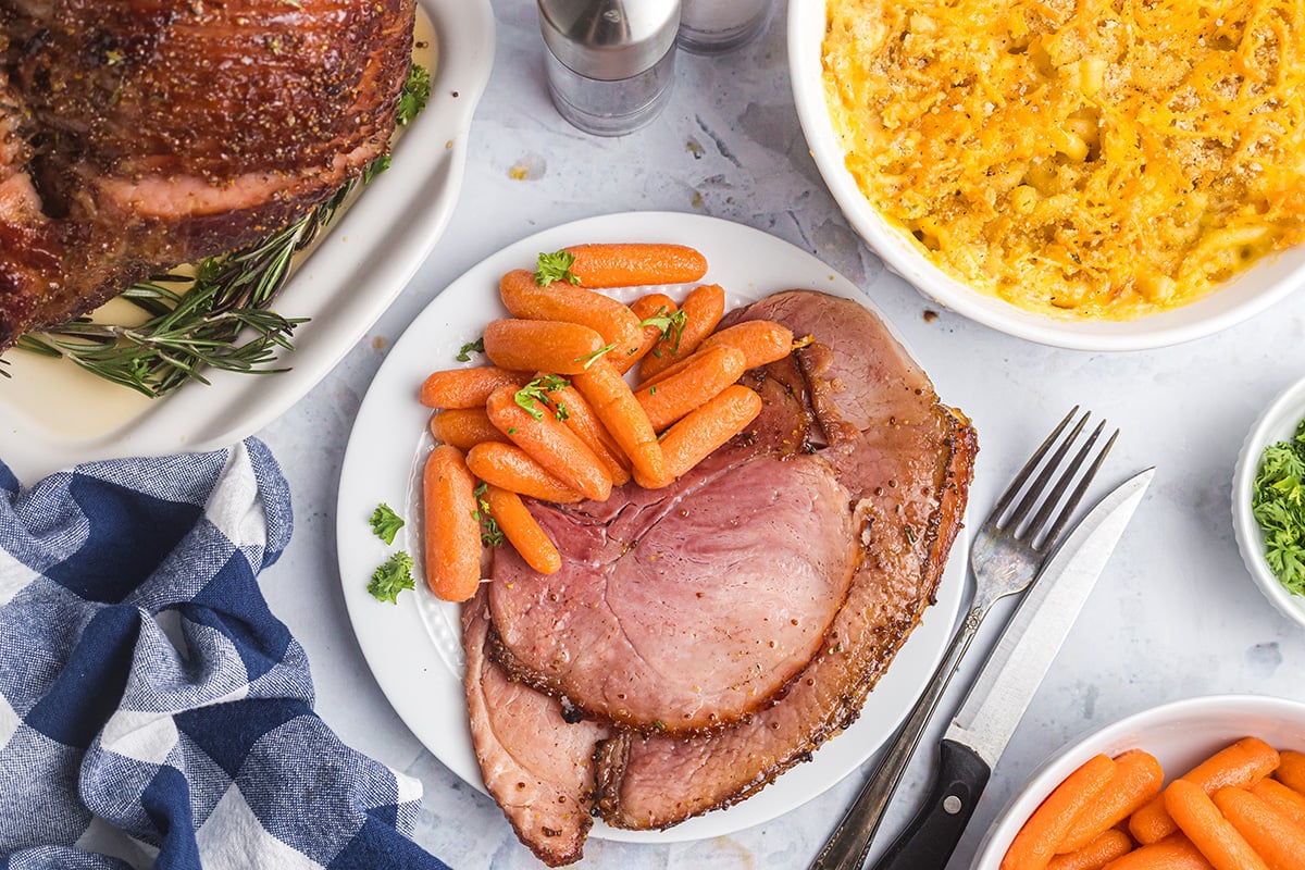 overhead shot of plate of slices of mustard brown sugar ham with carrots