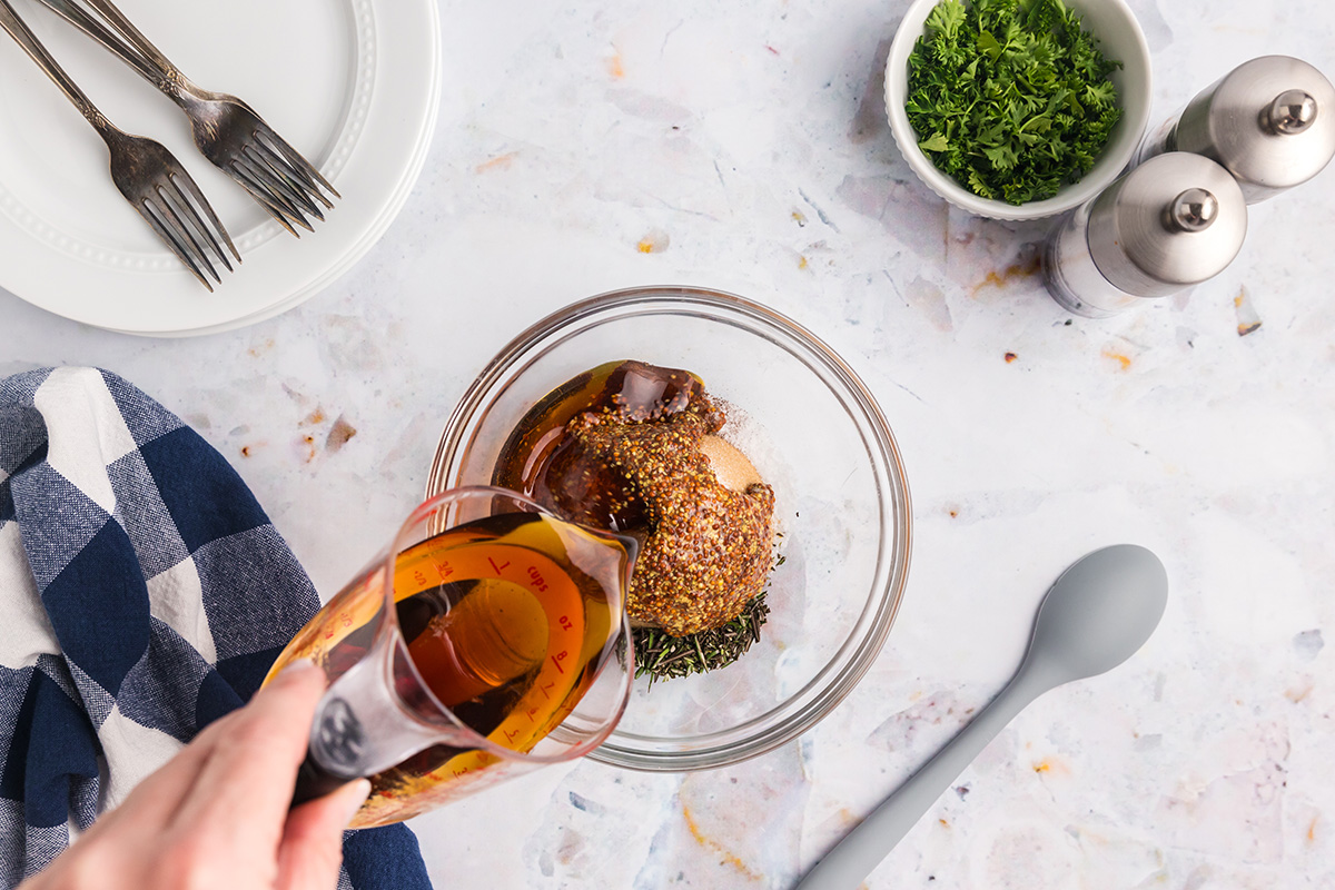 pouring honey into bowl of seasonings