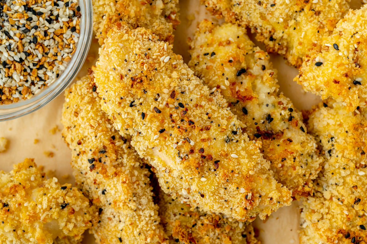 close up overhead shot of everything seasoning chicken tenders on sheet pan