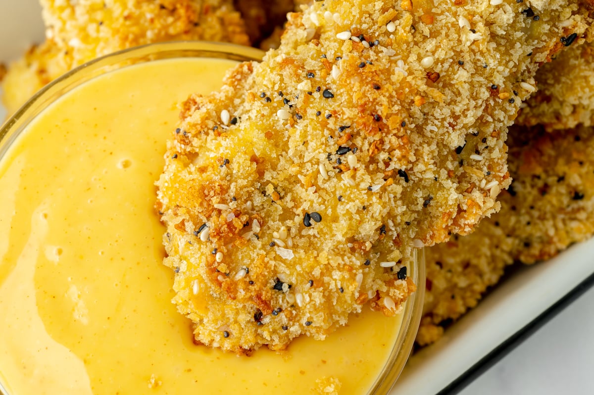 overhead shot of chicken tender dipping into honey mustard