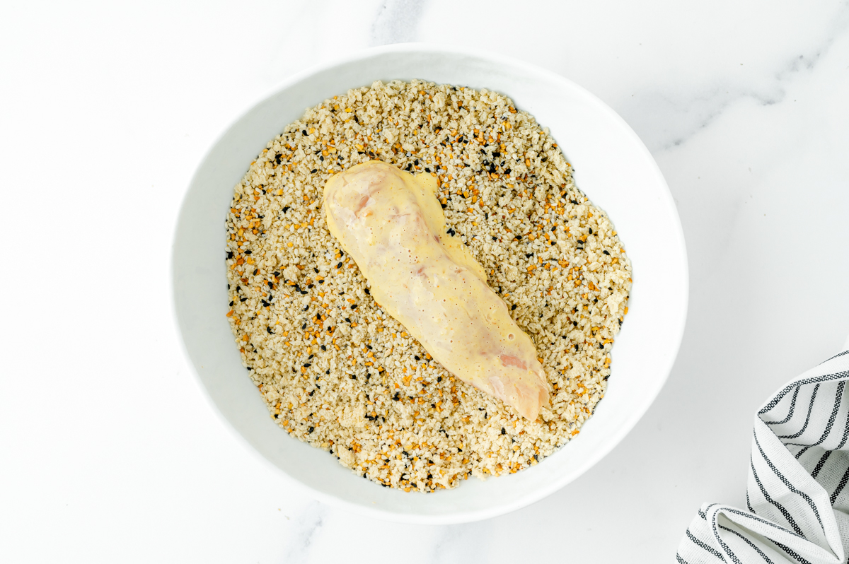 overhead shot of raw chicken tender in everything seasoning