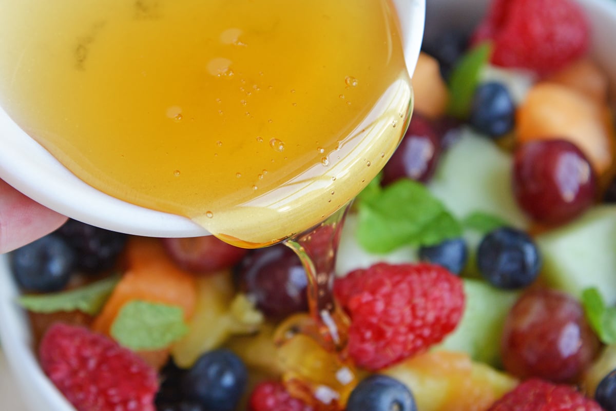 Agave nectar pouring over fruit salad