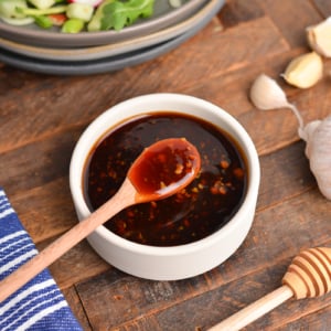 angled shot of spoon in bowl of honey garlic sauce