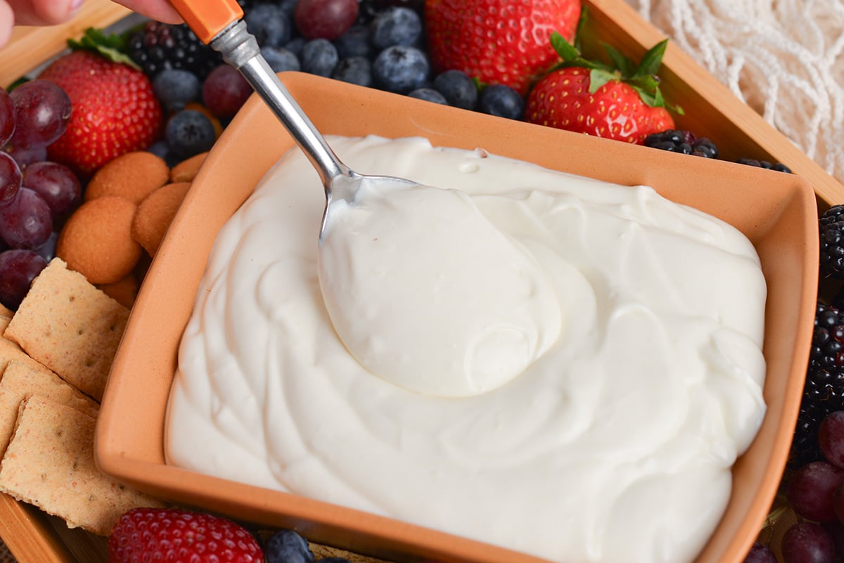 spoon dipping into fruit dessert dip