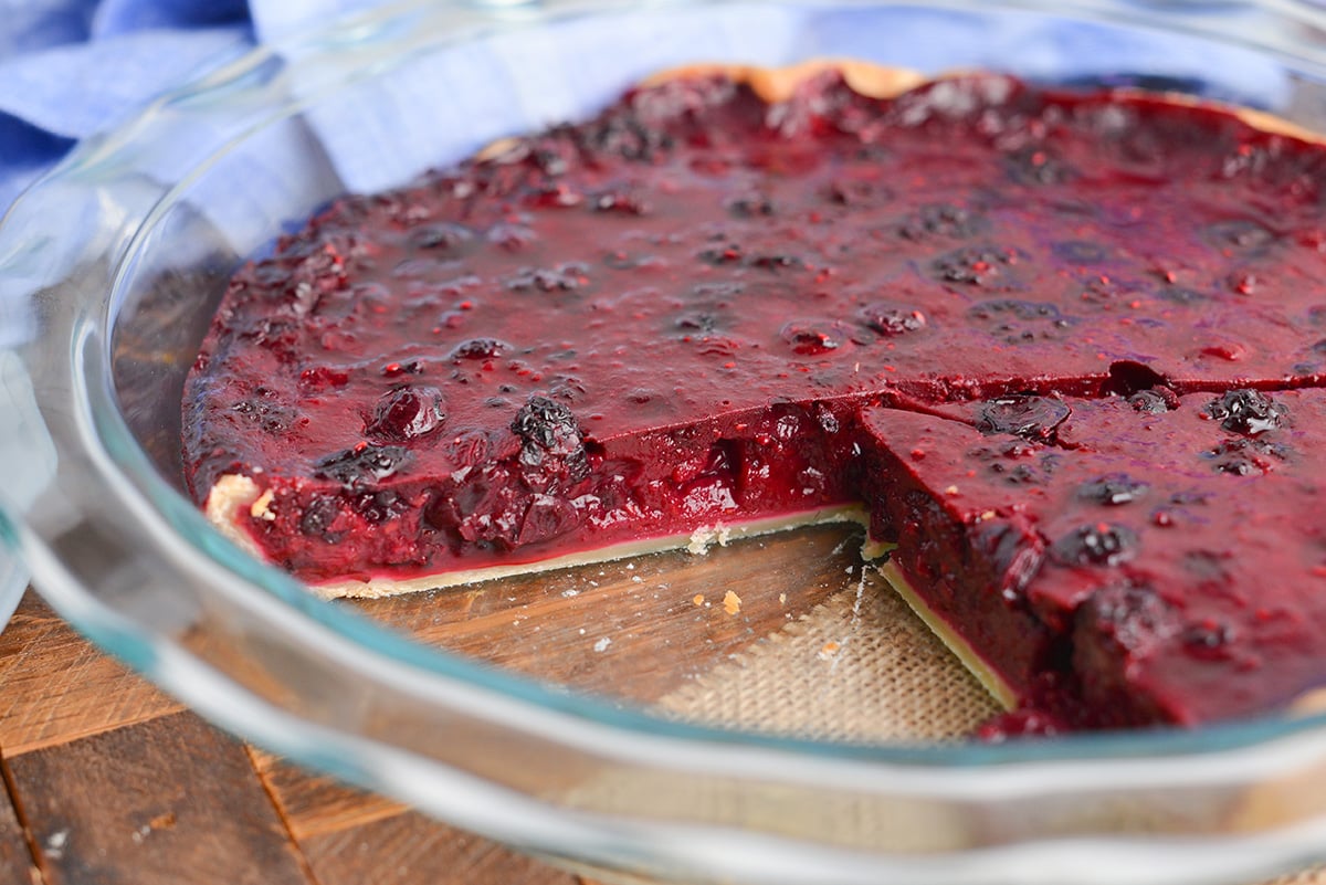 angled shot of slice taken out of mixed berry pie