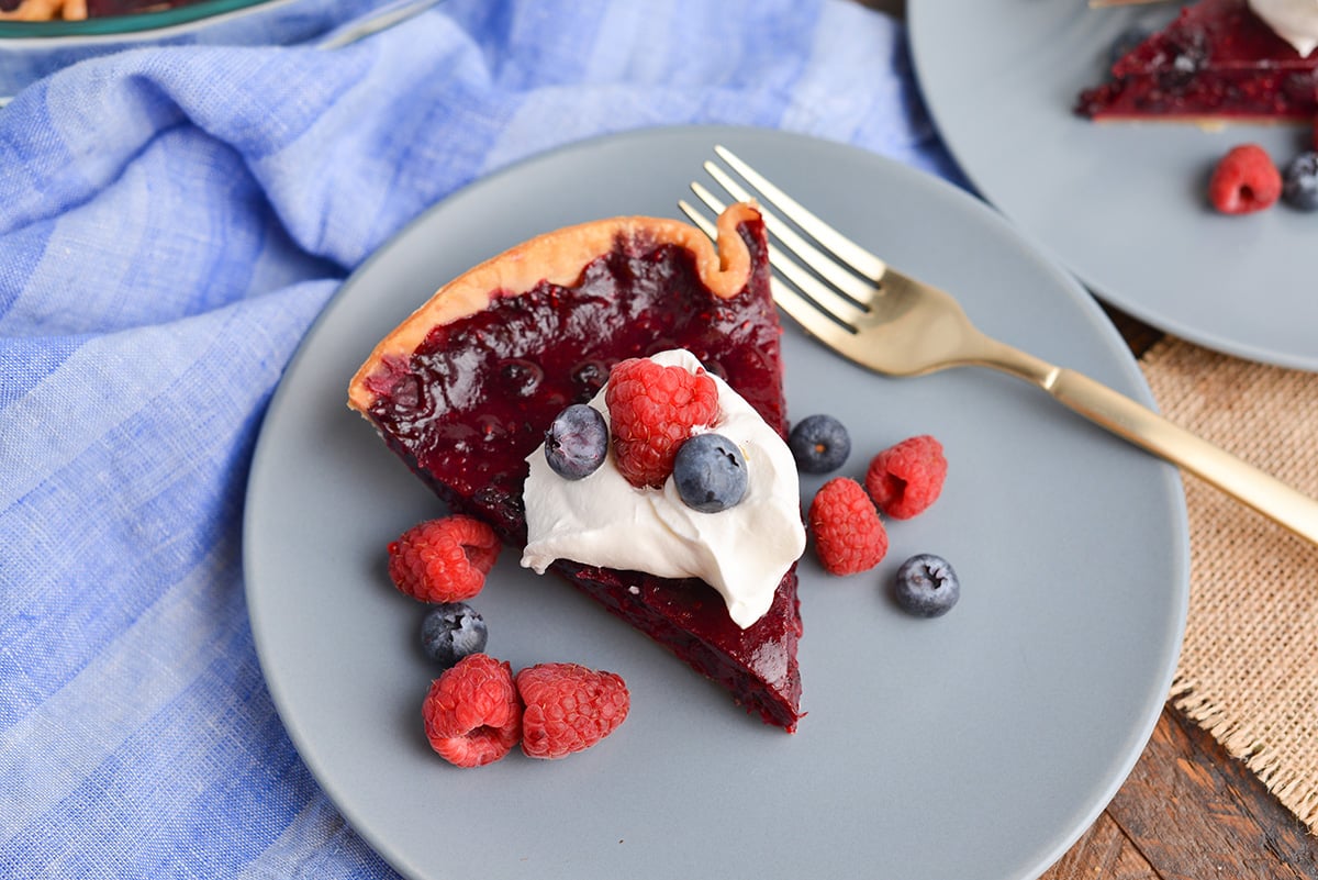 overhead shot of slice of mixed berry pie on plate