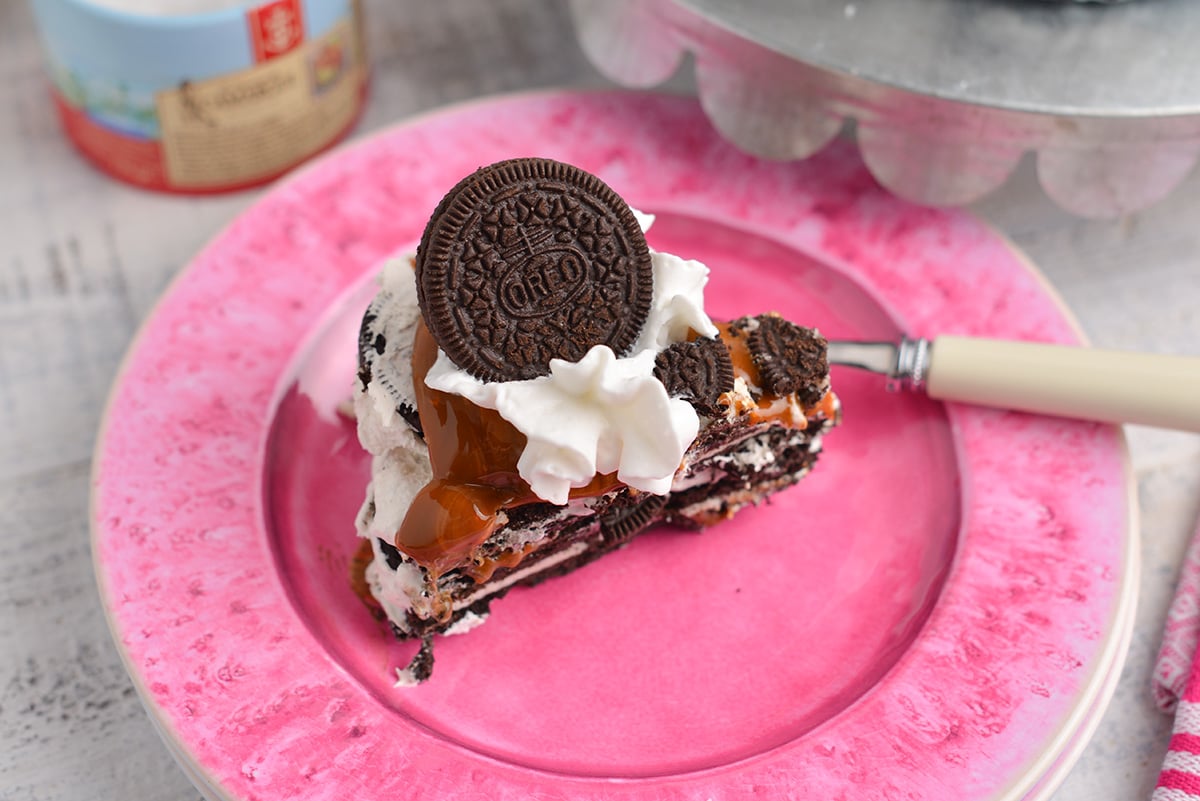 slice of oreo cake on a bright pink serving plate