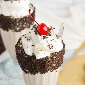 close up of oreo milkshake with whipped cream and a cherry