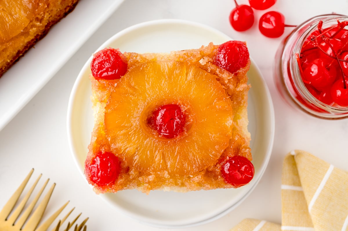 overhead of one slice of pineapple cake with maraschino cherries