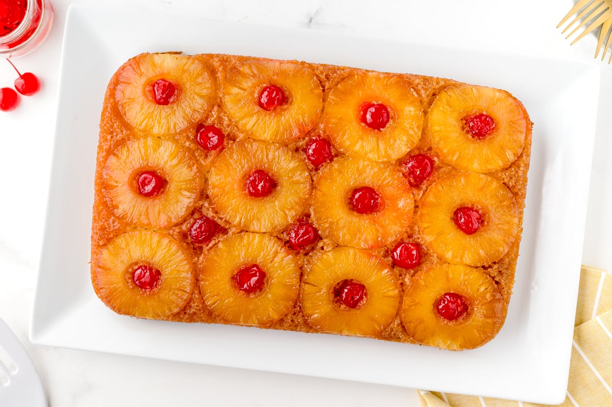 pineapple upside down cake with cherry on a serving plate