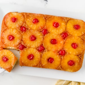 overhead of upside down pineapple cake at an angle with one slice cut out