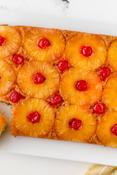 overhead of upside down pineapple cake at an angle with one slice cut out