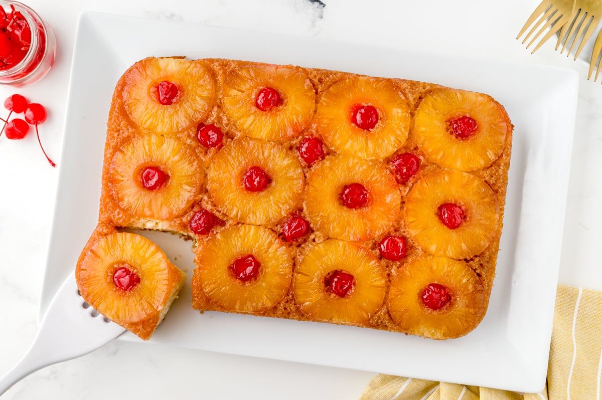 overhead of upside down pineapple cake at an angle with one slice cut out