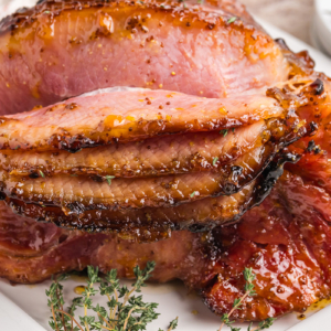 straight on shot of riesling peach glazed ham sliced on platter