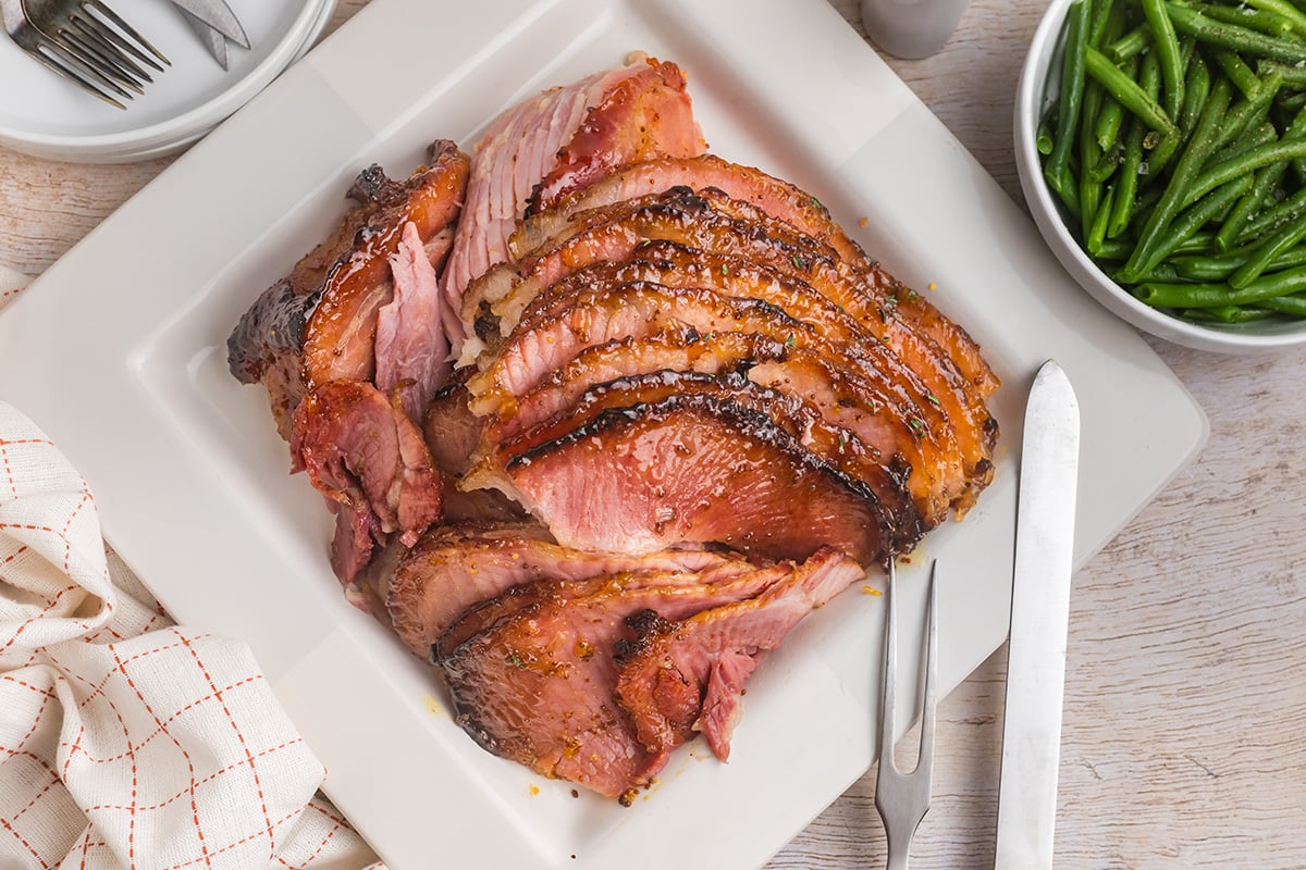 overhead shot of sliced rielsing peach glazed ham on platter