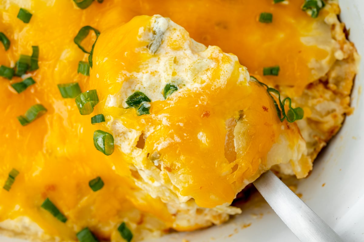 overhead shot of spoon full of slow cooker potatoes au gratin