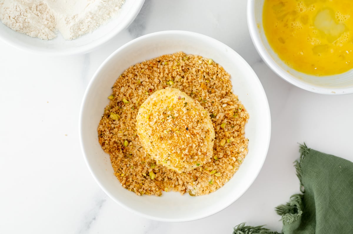 ball of burrata in bowl of crushed pistachios