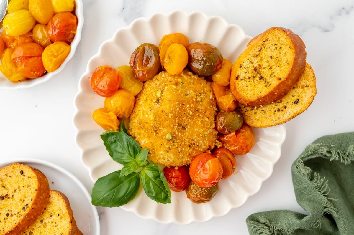 overhead shot of air fryer burrata on plate with tomatoes and garlic bread