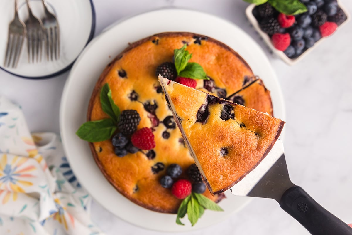 overhead shot of slice of berry ricotta cheesecake slice on spatula