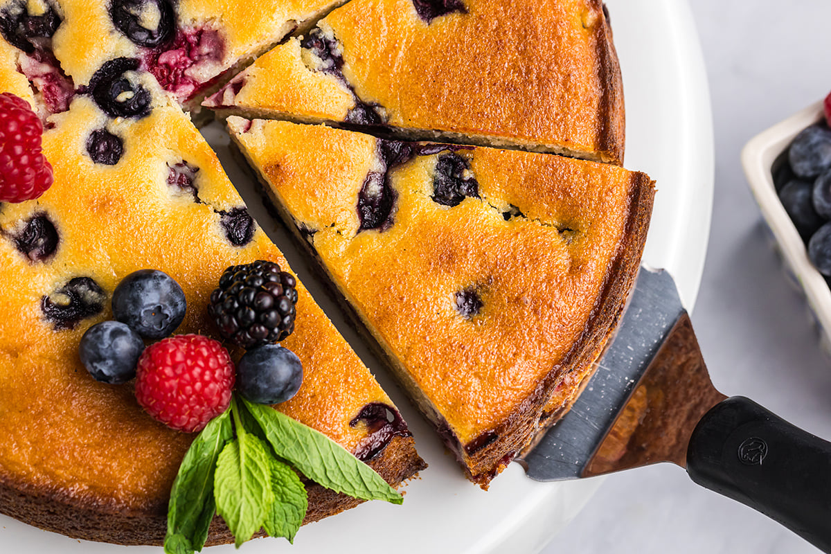 close up of slice of berry ricotta cheesecake slice on spatula