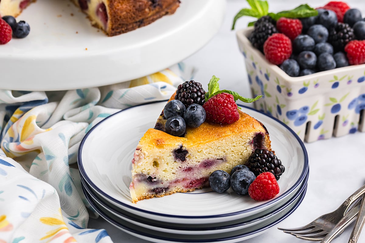 angled shot of slice of berry ricotta cheesecake on plate